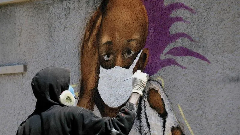 Serigne 'Zeus' Boye, a graffiti artist, works on his mural to encourage people to protect themselves amid the COVID-19 outbreak in Dakar, Senegal on March 25, 2020 [File: Zohra Bensemra/Reuters]